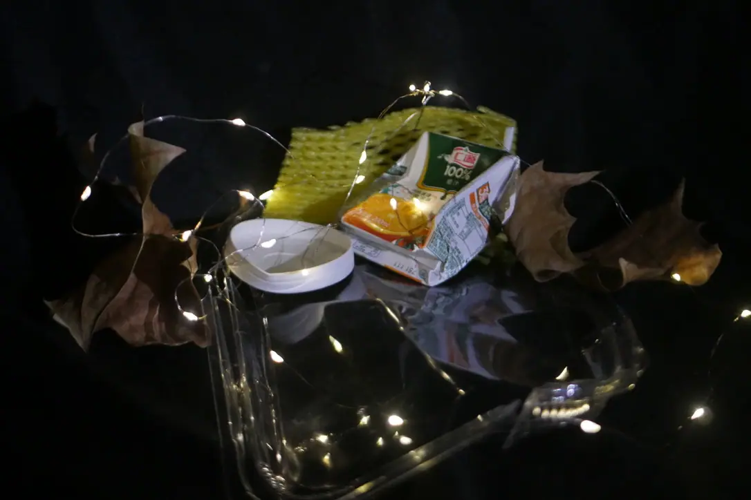 Still life of juice, a bowl and autumn leaves with fairy lights