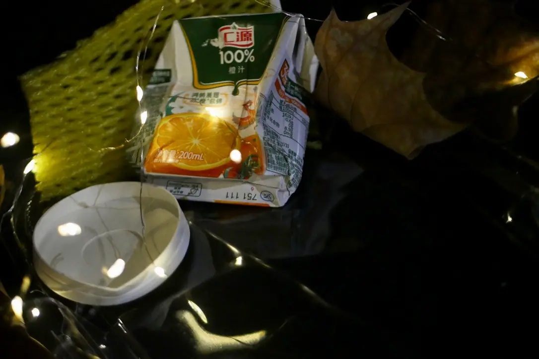 Still life of a juice carton and glass bowl with lights